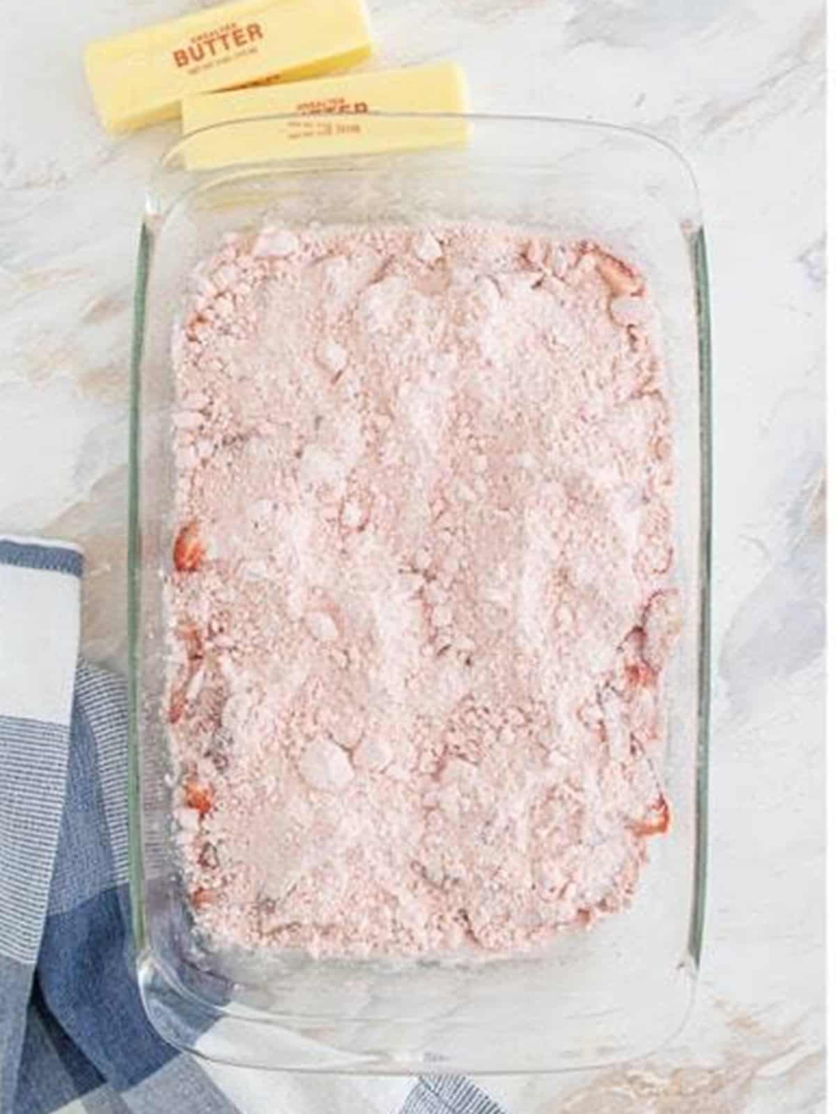 Strawberry cake mix spread evenly over the strawberry layer.