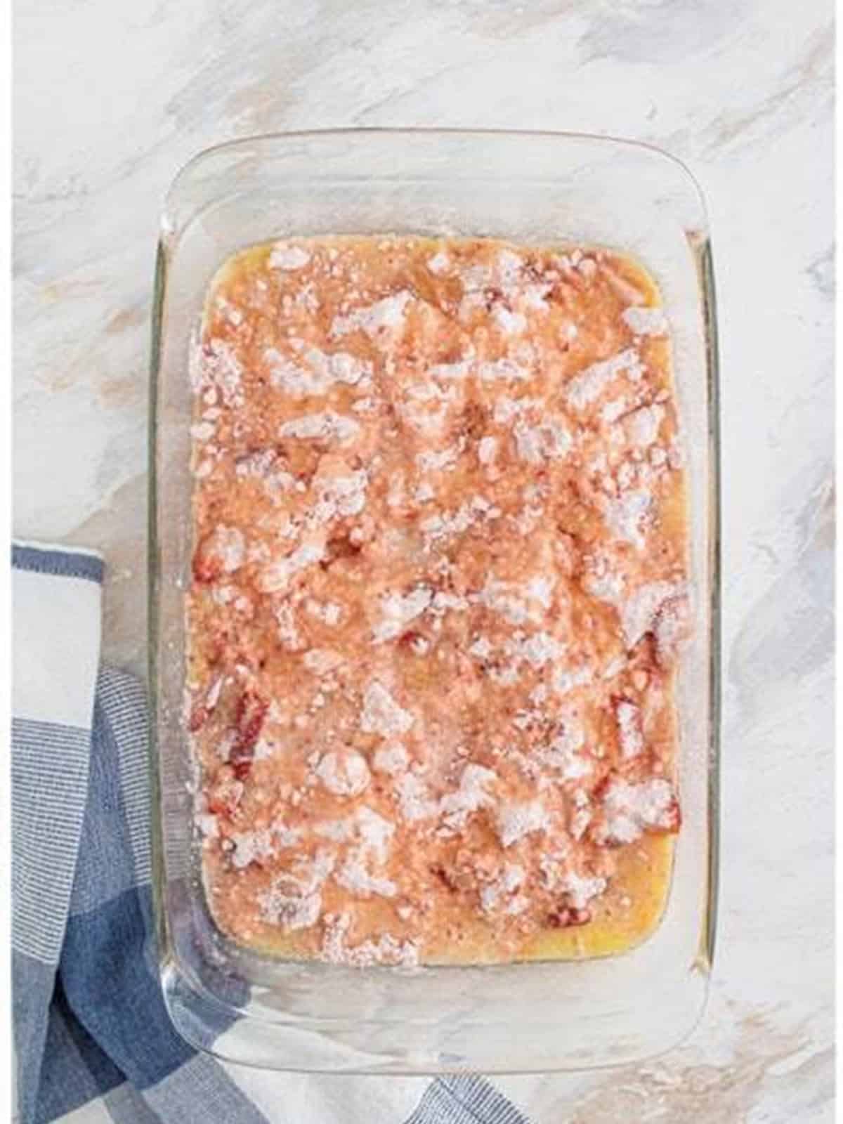Melted butter drizzled over the cake mix for Strawberry Dump Cake.