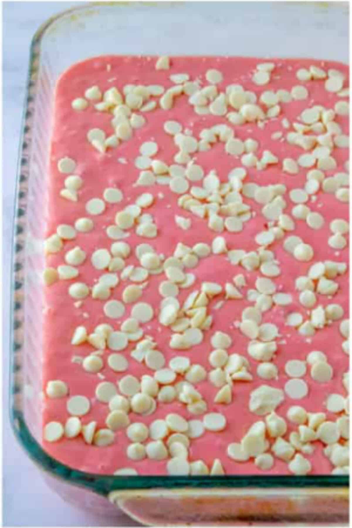 Strawberry cake batter topped with white chocolate chips.