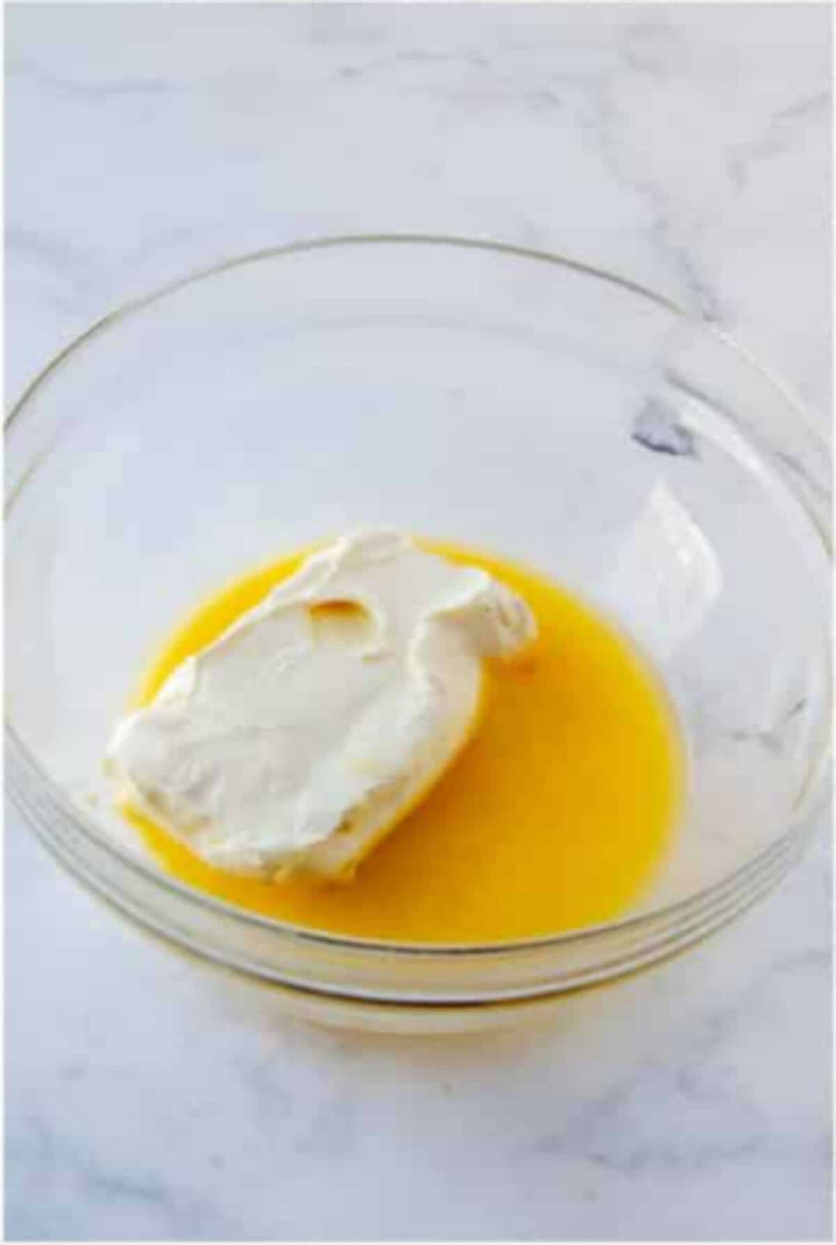 Melted butter and cream cheese in a bowl for the cheesecake layer.