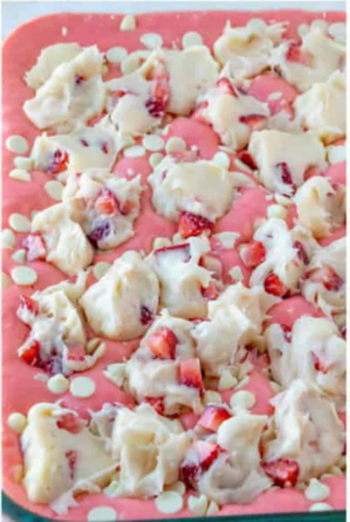 Strawberry earthquake cake topped with white chocolate and strawberries before baking.
