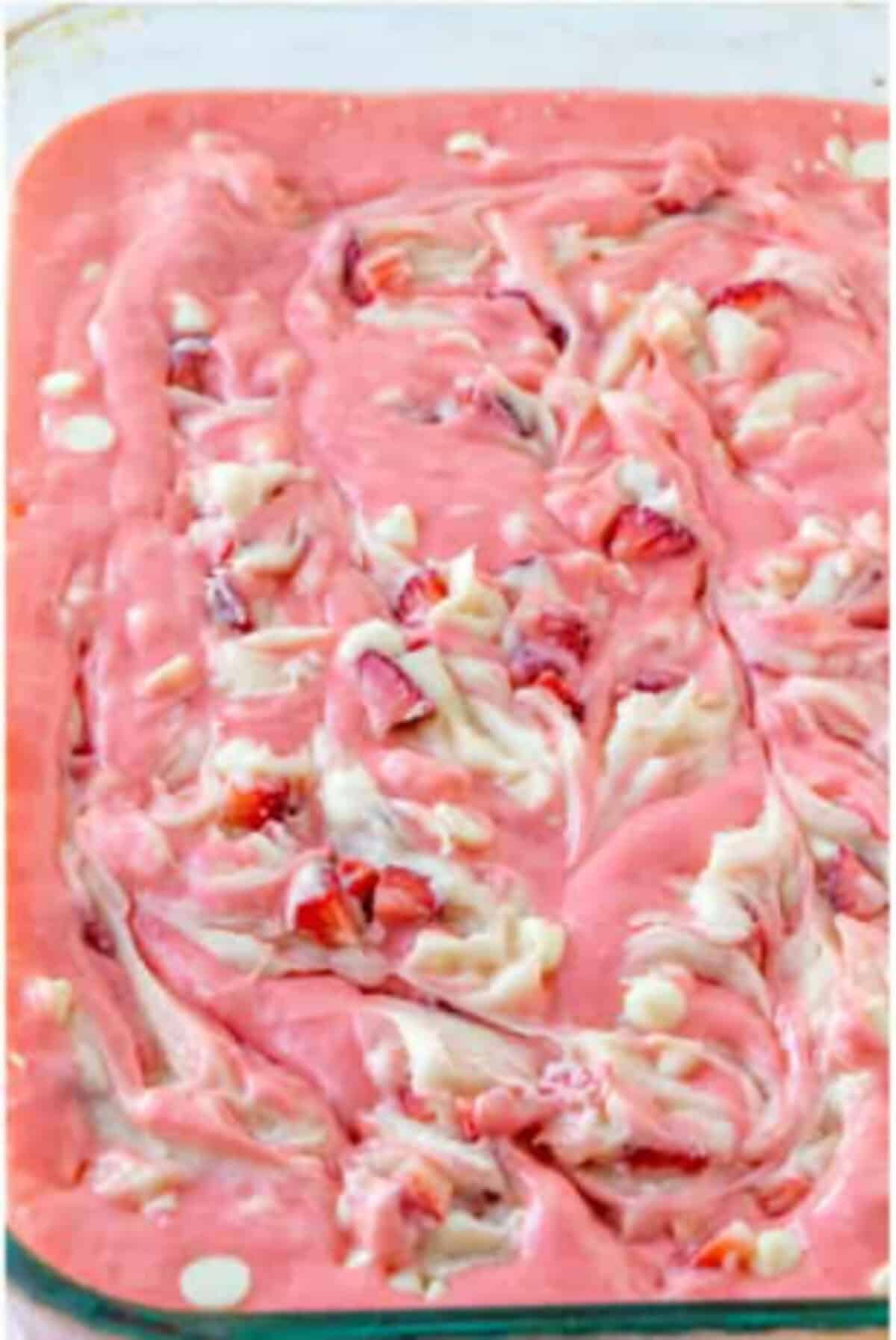 Baked strawberry earthquake cake with a pink and white cheesecake swirl in the dish.