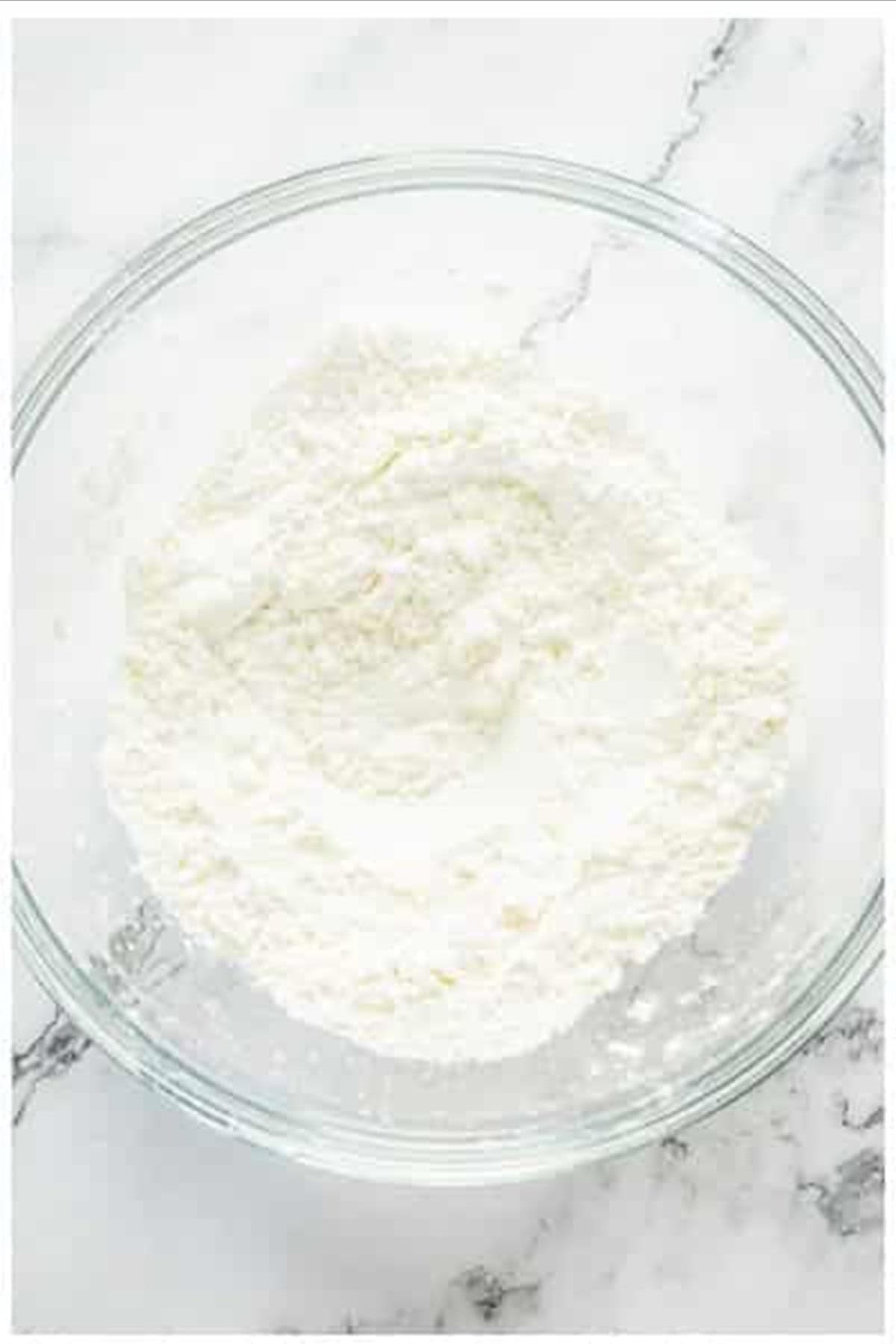 Dry batter ingredients whisked together in a glass bowl for sweet and sour chicken.