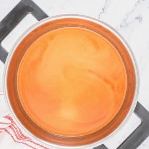 Sweet and Sour Sauce with ketchup just whisked in turning orange in the saucepan.