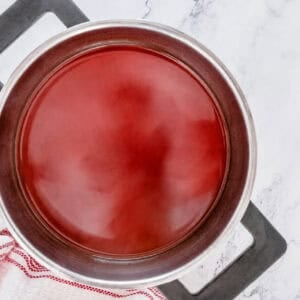 Sweet and Sour Sauce fully combined to a deep red color in the saucepan before slurry.