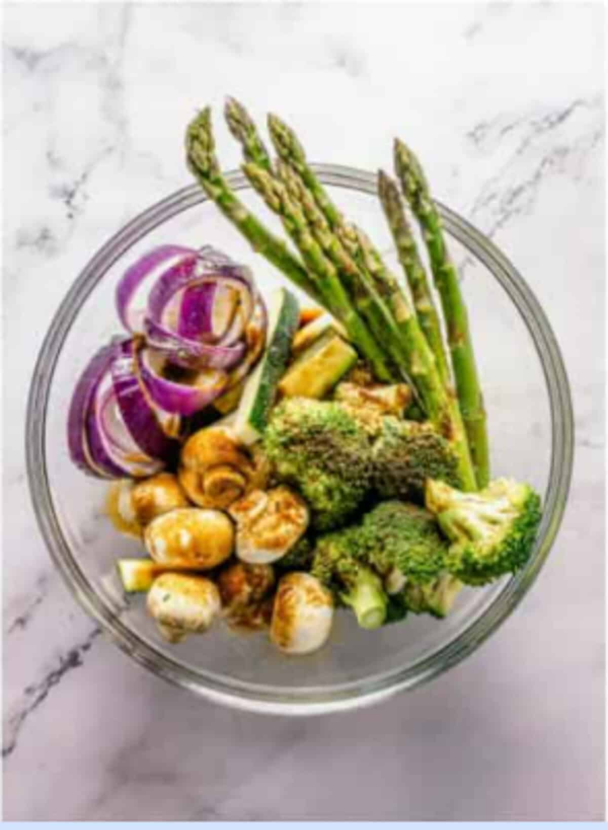 Sliced veggies tossed with soy sauce, garlic powder, onion powder, cornstarch, and black pepper marinating in a large bowl for the Crispy Tempura Vegetables Recipe.