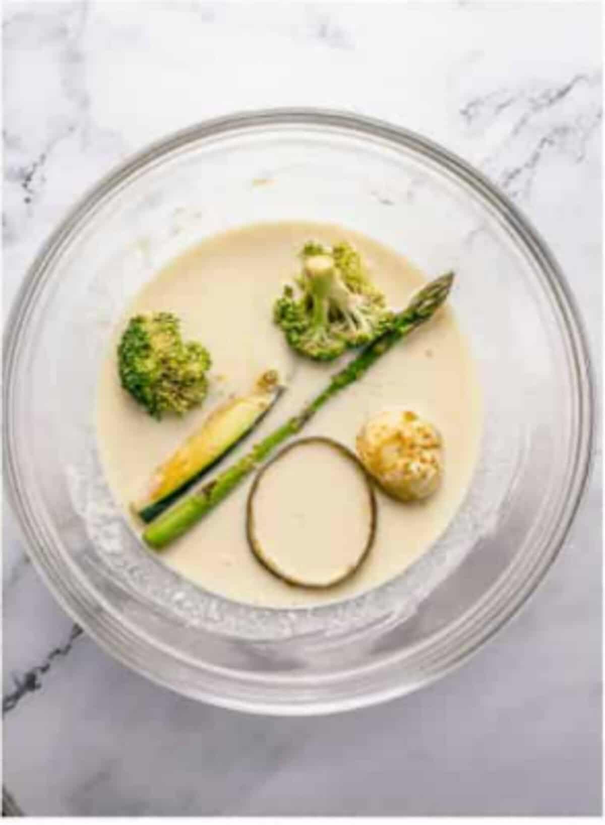 The wet egg-water mix being stirred into the dry batter ingredients with visible lumps remaining (the secret to crispy tempura) plus marinated veggies tossed with extra cornstarch for the Crispy Tempura Vegetables Recipe.