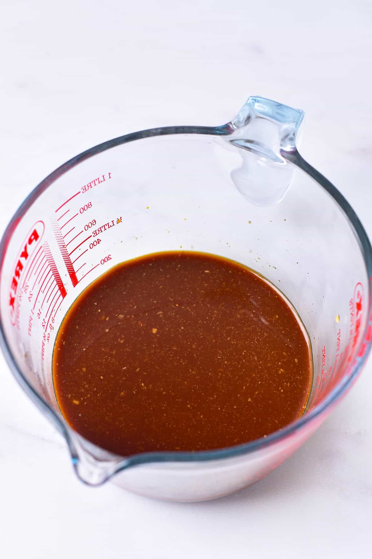 Teriyaki sauce mixture of soy sauce, brown sugar, garlic, ginger, and apple cider vinegar stirred together in a glass measuring cup for Panda Express Teriyaki Chicken Recipe.