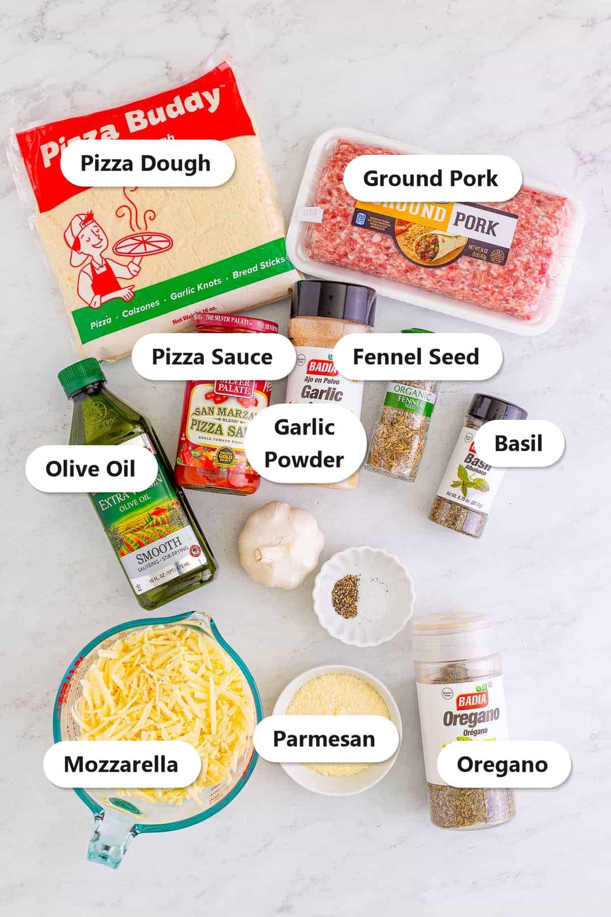 Labeled ingredients for The Best Sheet Pan Pizza Recipe including pizza dough, ground pork, olive oil, pizza sauce, garlic powder, fennel seed, basil, mozzarella, Parmesan, and oregano.
