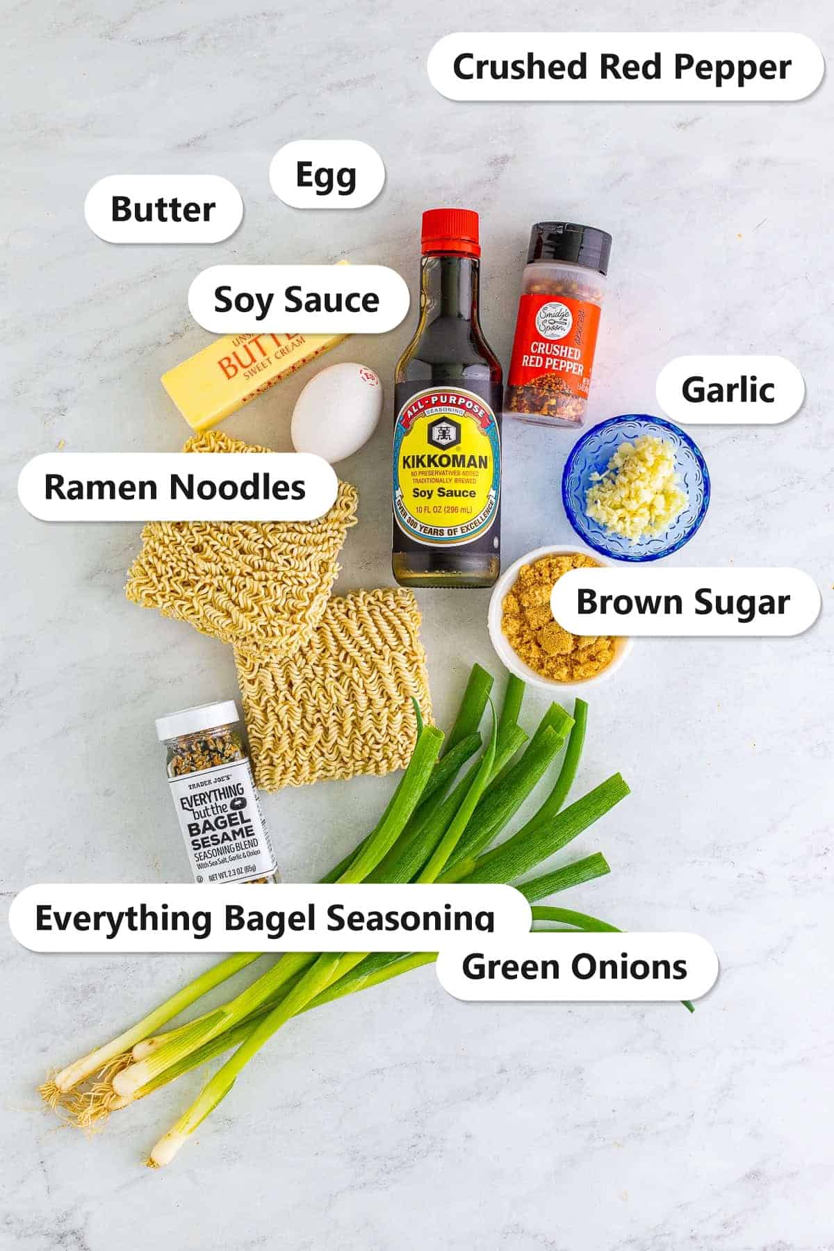Labeled ingredients for viral TikTok ramen noodles including butter, egg, ramen noodles, soy sauce, crushed red pepper, garlic, brown sugar, everything bagel seasoning, and green onions.