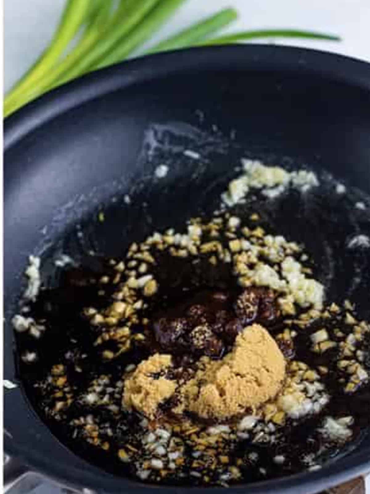 Adding soy sauce, brown sugar, and red pepper flakes to the skillet.