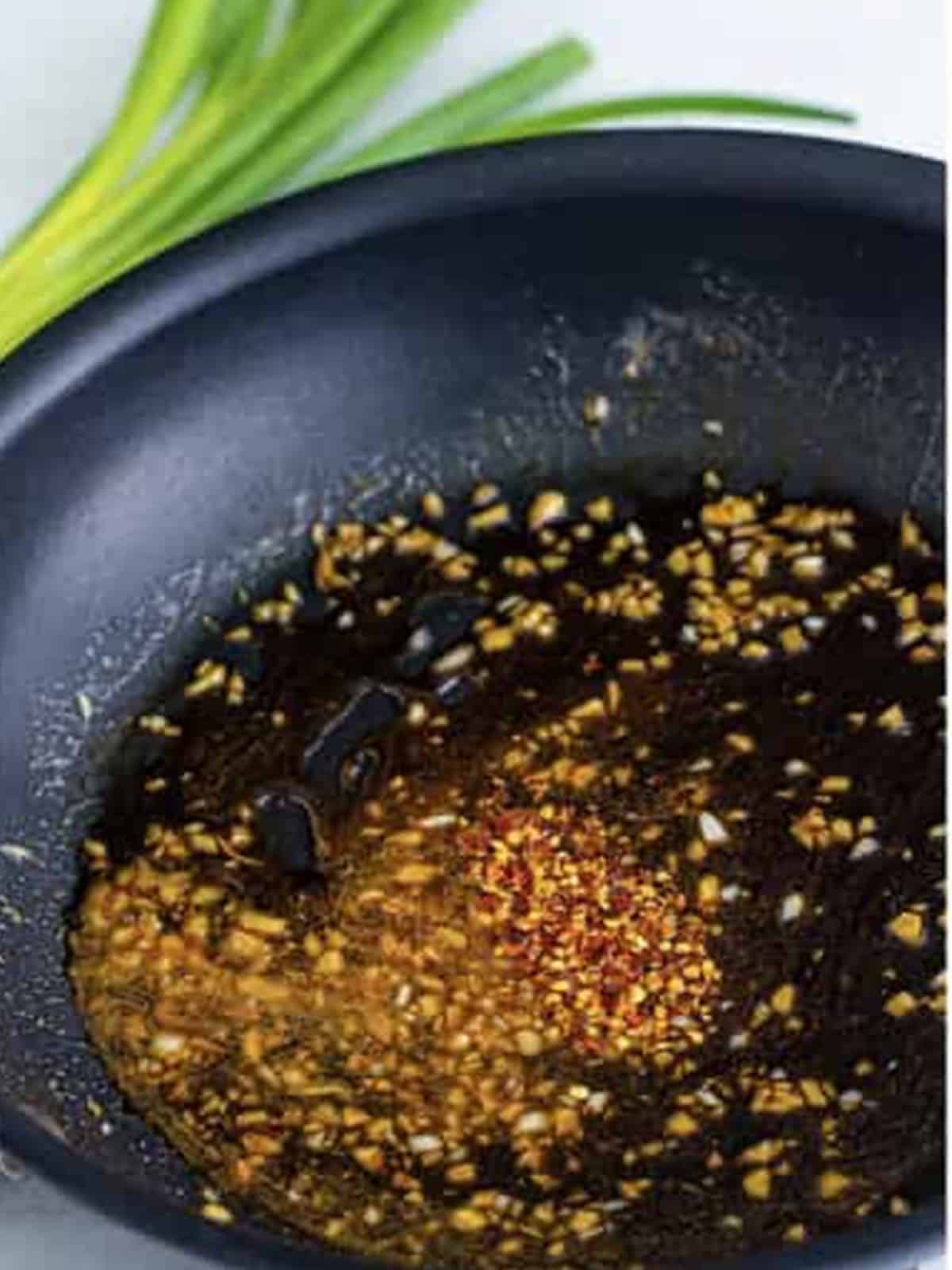 Stirring the soy sauce and brown sugar glaze with red pepper flakes.