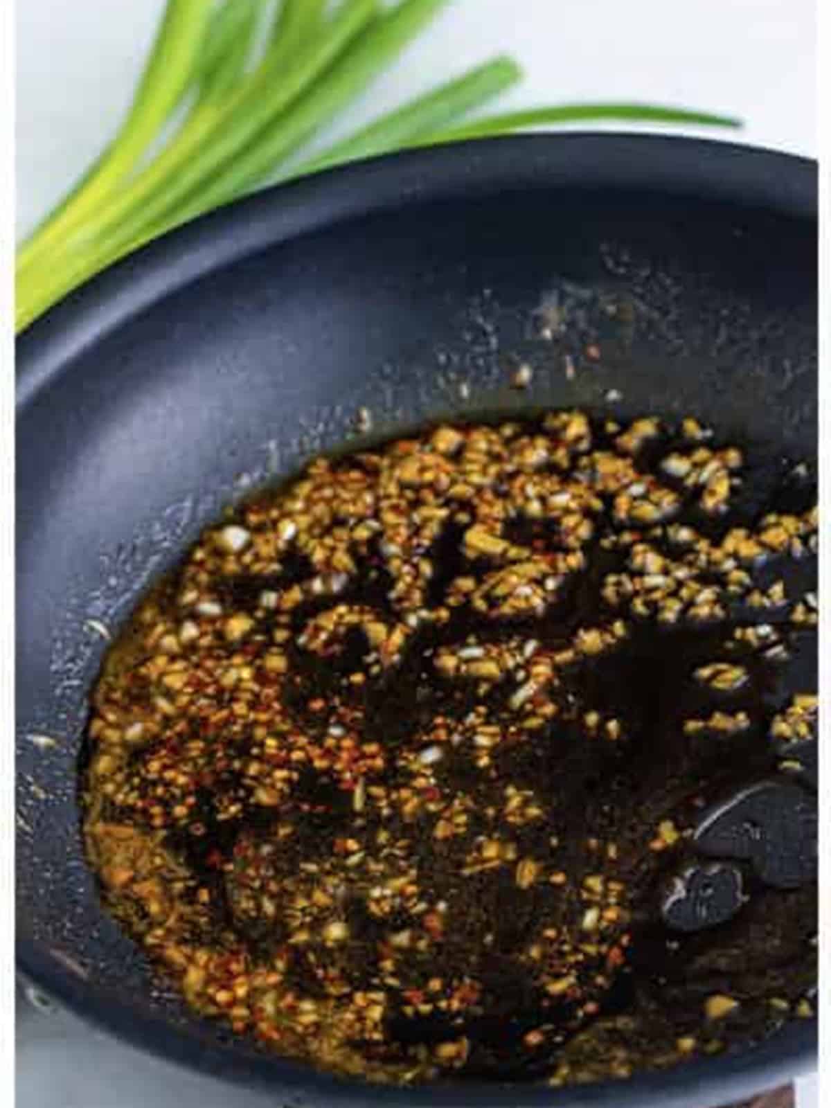 Simmering the sweet and savory sauce until bubbling.