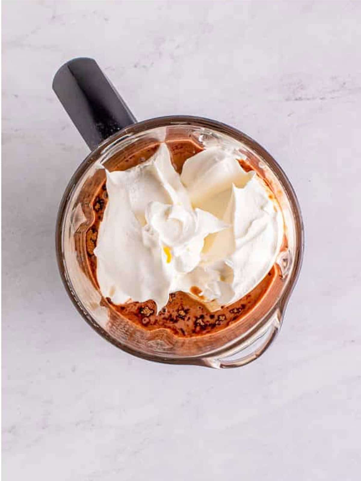 Chocolate milk, Nesquik, condensed milk, and whipped topping in a blender for Wendys Frosty.
