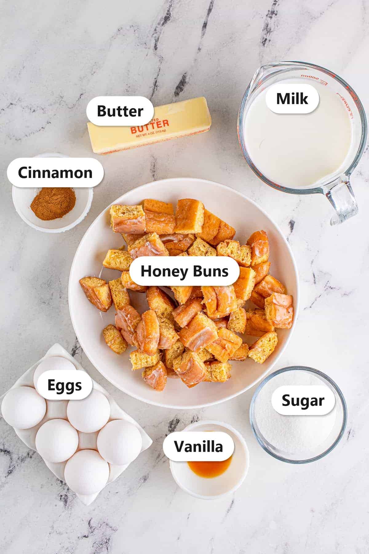 Ingredients to make Honey Bun Bread Pudding labeled including honey buns, eggs, milk, butter, sugar, cinnamon, and vanilla.