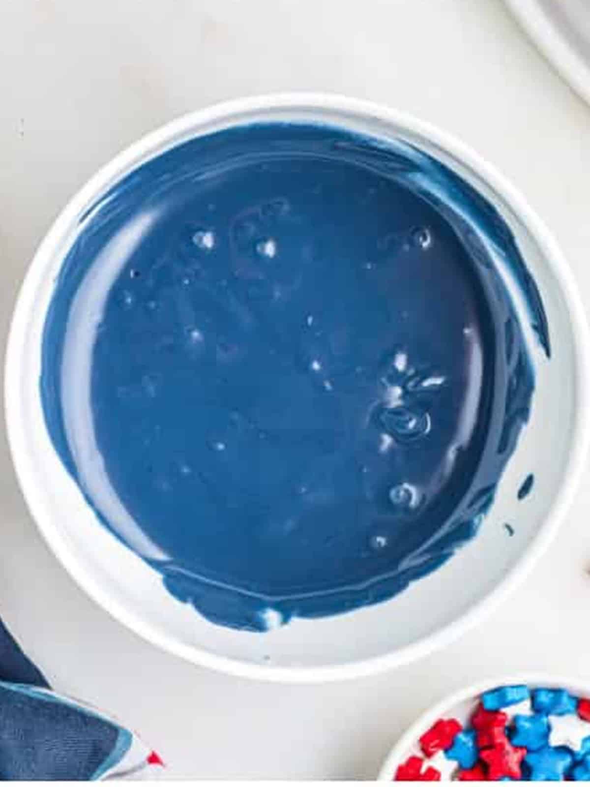 Melted blue candy melts in a bowl for decorating a 4th of July Cake.
