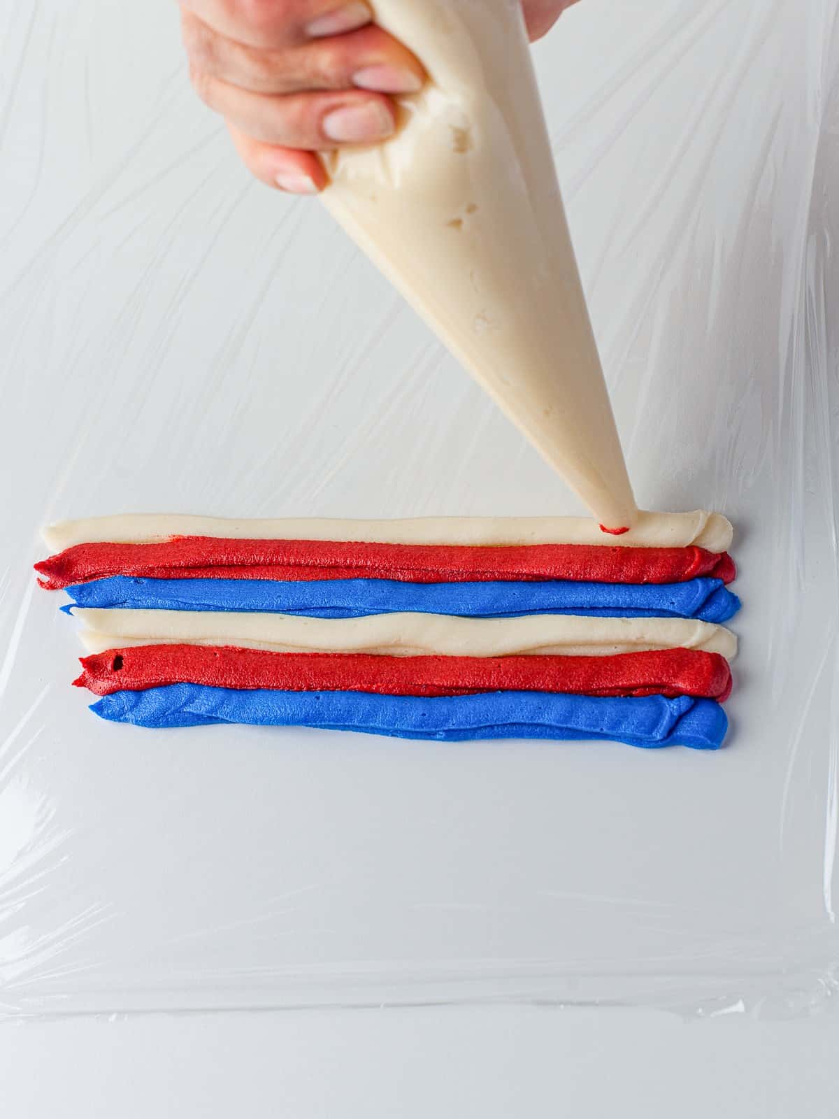 Red, white, and blue buttercream layered in a piping bag.