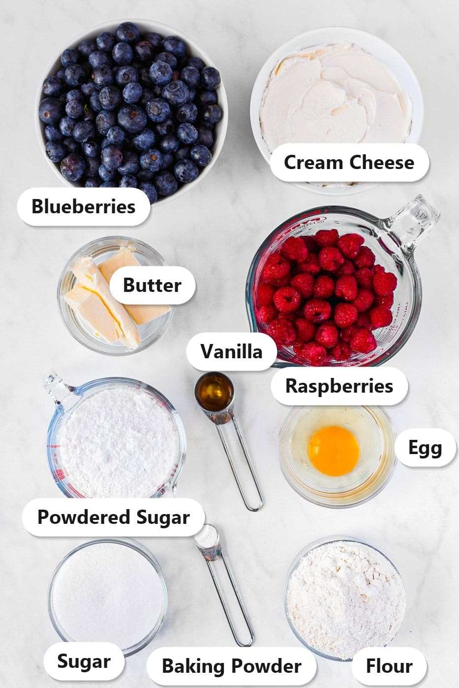 Labeled ingredients for 4th of July fruit pizza including blueberries, raspberries, cream cheese, butter, sugar, powdered sugar, egg, vanilla, flour, and baking powder.