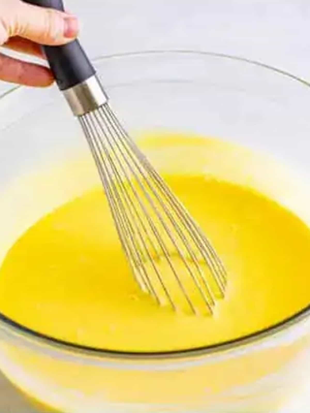 Whisking vanilla pudding in a glass bowl for a 4th of July Trifle.
