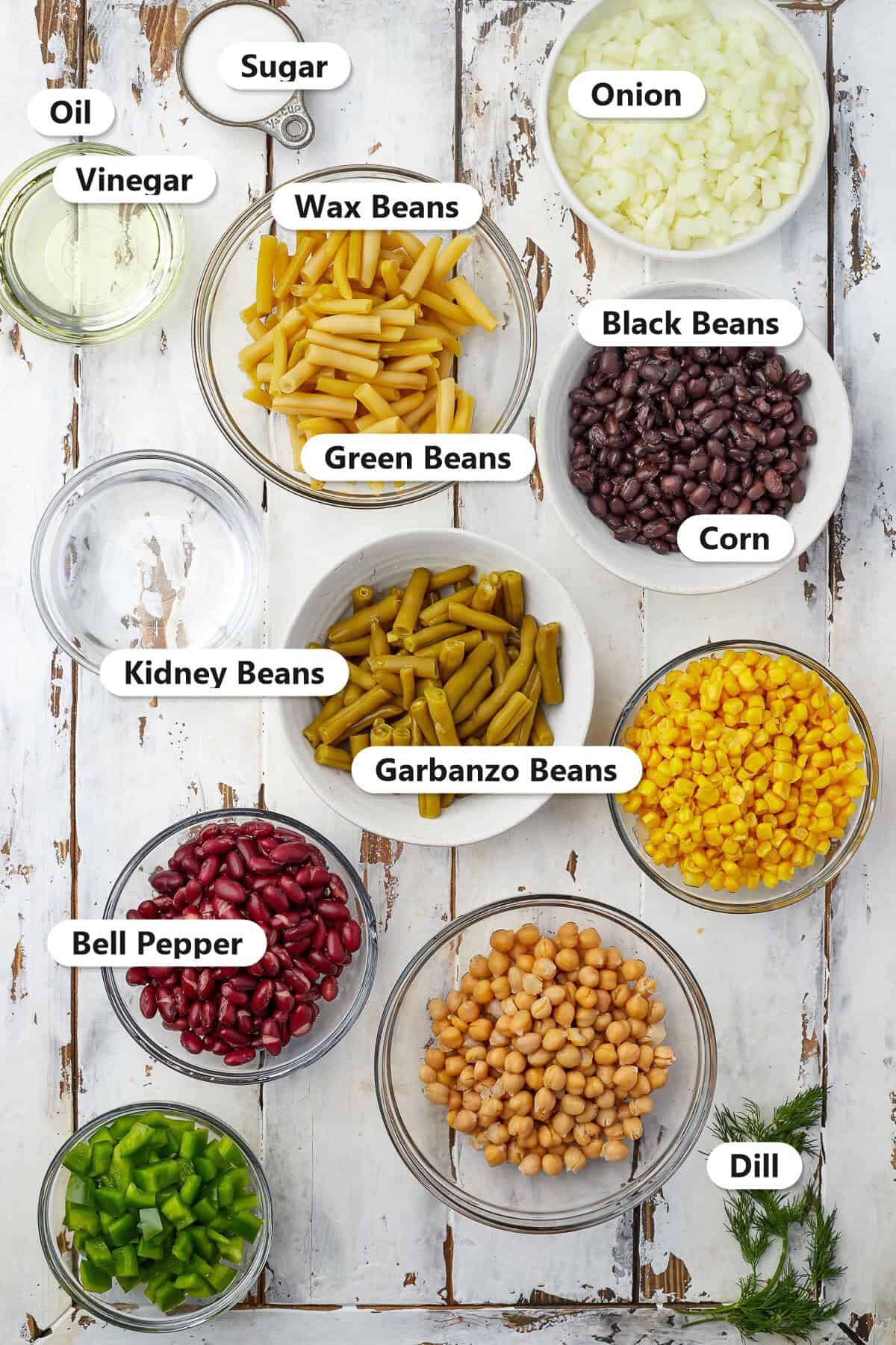 Labeled 5 bean salad ingredients including green beans, wax beans, kidney beans, black beans, garbanzo beans, corn, onion, bell pepper, dill, vinegar, oil, and sugar.
