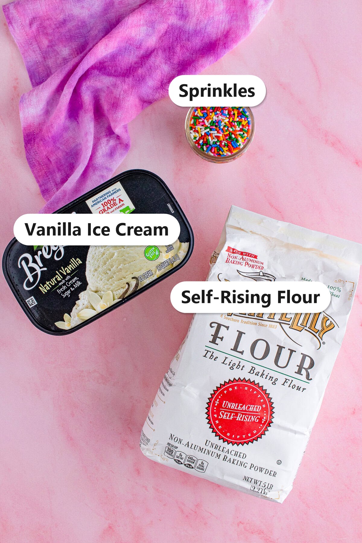 Labeled ingredients for 2 ingredient ice cream bread including vanilla ice cream, self-rising flour, and rainbow sprinkles.