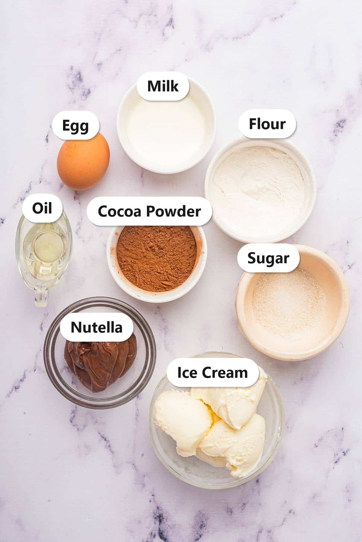 Ingredients to make a Nutella Mug Cake labeled including flour, sugar, cocoa powder, oil, milk, Nutella, egg, and ice cream.