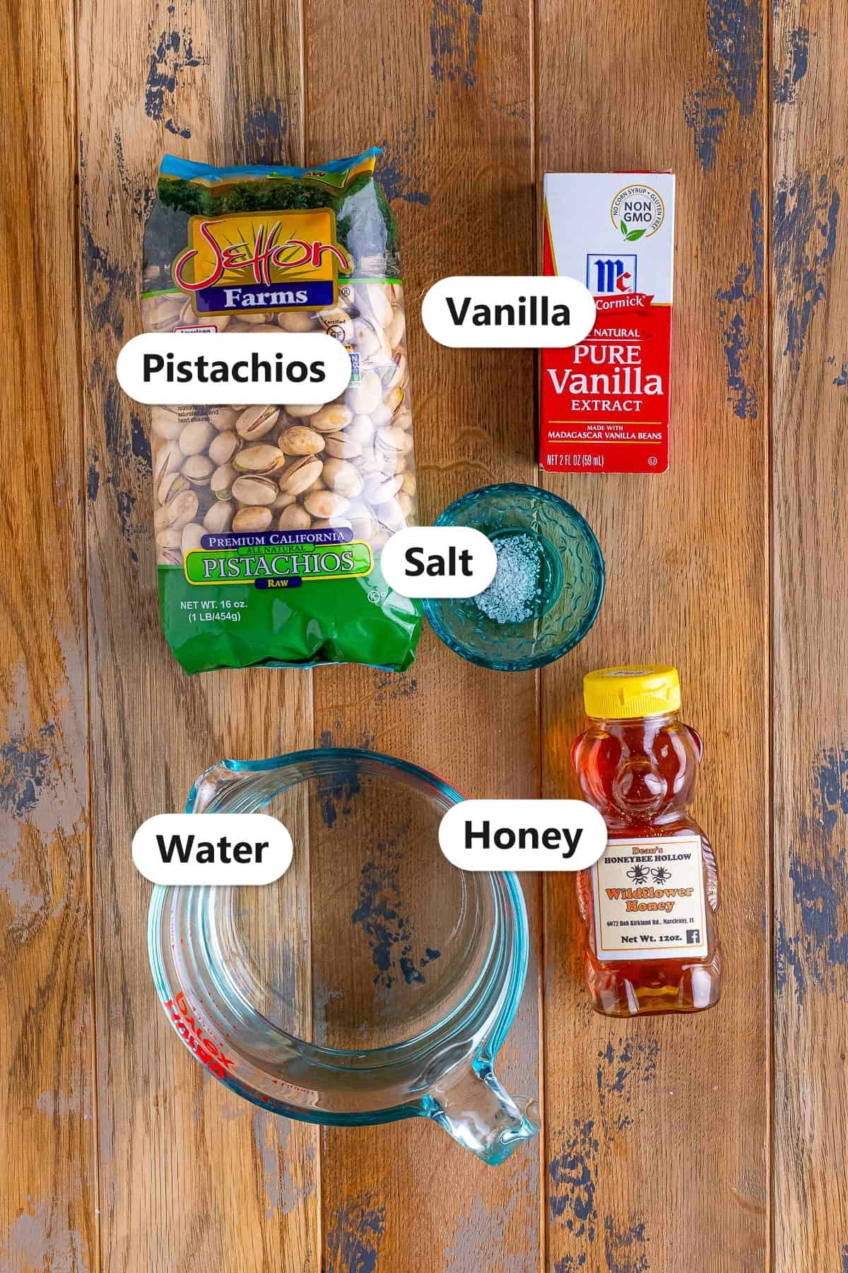 Labeled ingredients for homemade pistachio cream: pistachios, vanilla, salt, water, and honey.