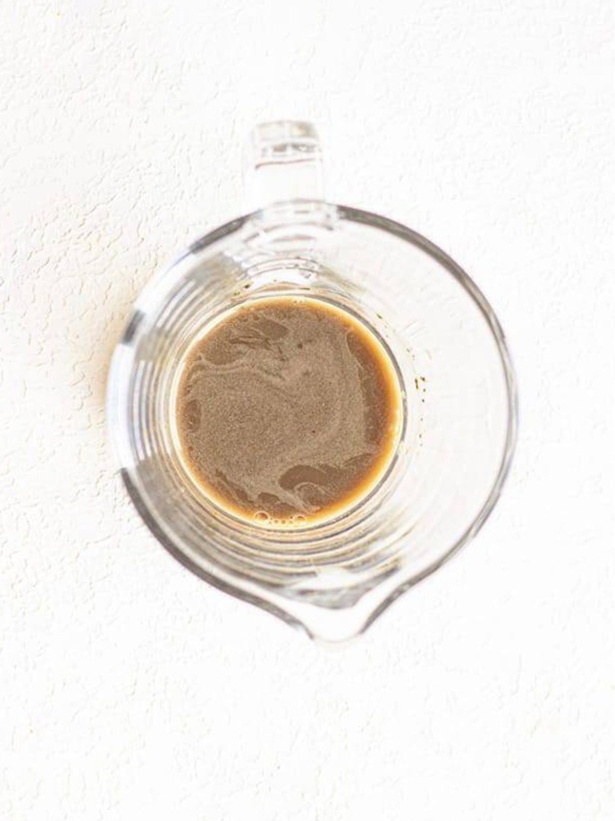 Acai, green tea, and passion fruit powders whisked with water in a glass bowl.
