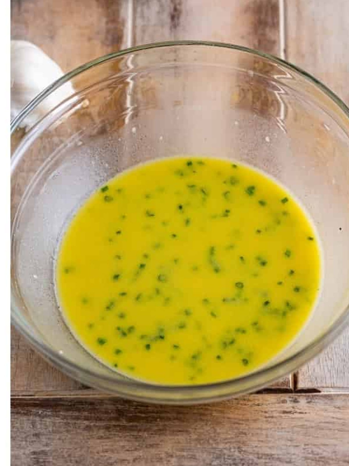 Finished apple cider vinegar dressing with chives in a bowl.