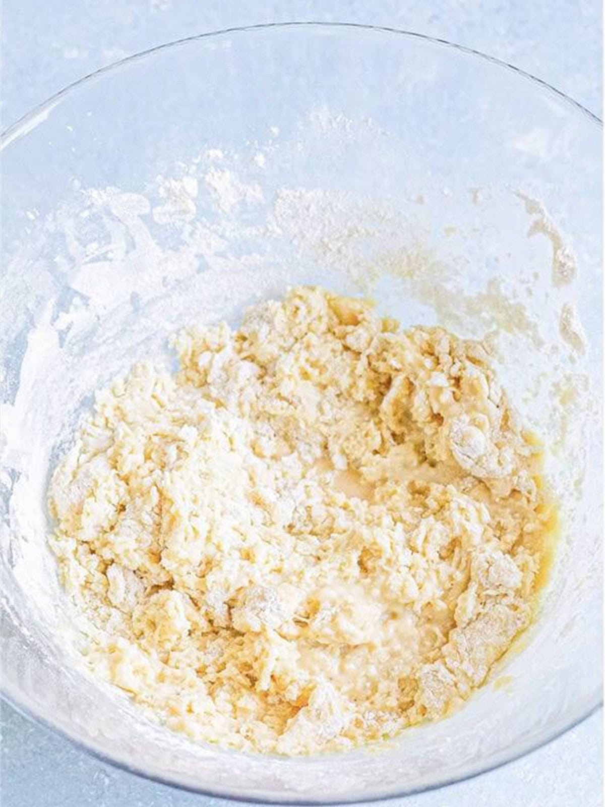 Flour mixed into the wet ingredients to form a shaggy cinnamon roll dough.