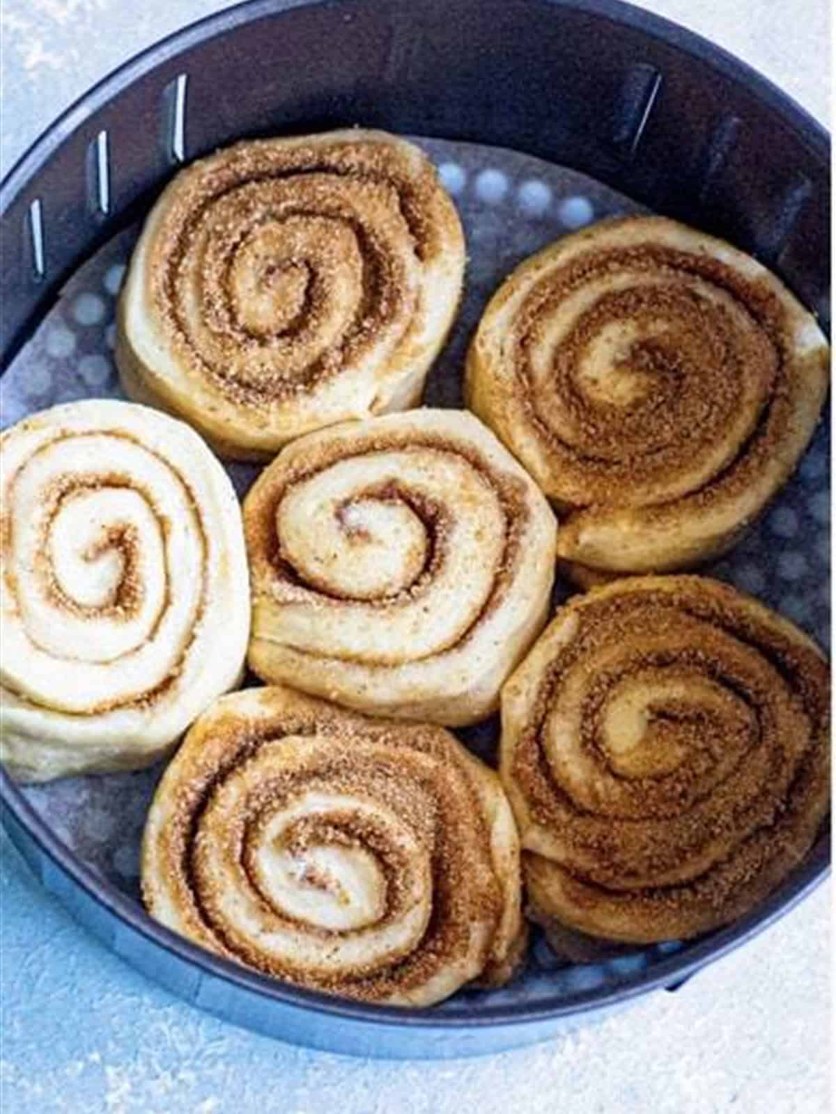 Cinnamon roll dough rolled into a log and cut into 12 spiral rolls.