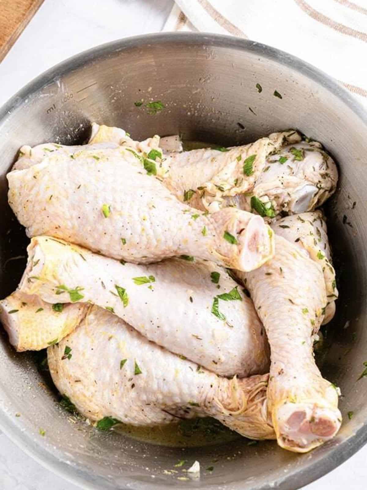 Raw chicken drumsticks tossed in lemon herb marinade.