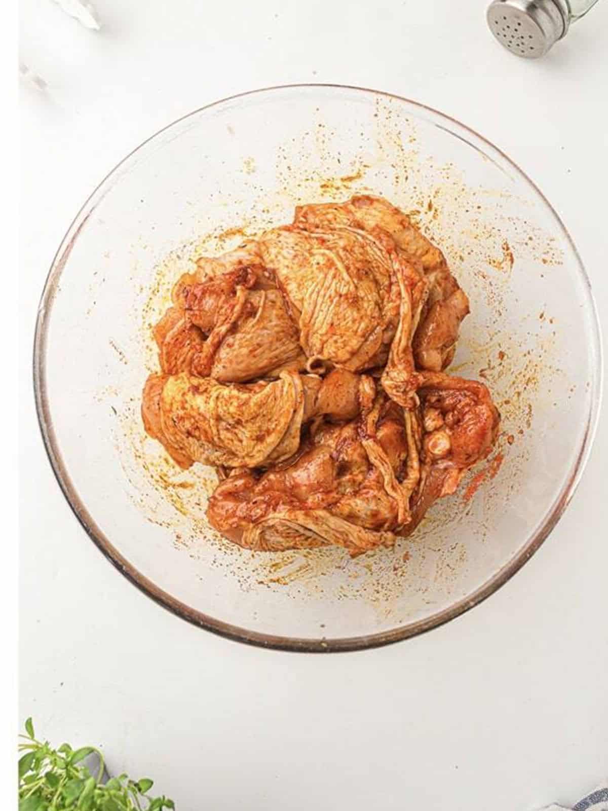 Chicken thighs rubbed all over and evenly coated in the seasoning for air fryer chicken thighs.