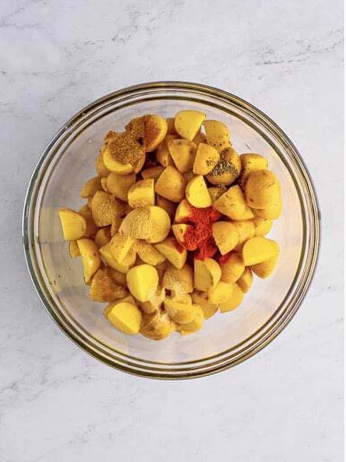 Diced baby Yukon gold potatoes in a glass bowl for air fryer home fries.