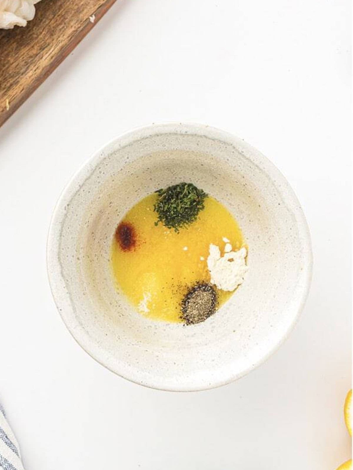 Melted butter mixed with seasonings in a small bowl.