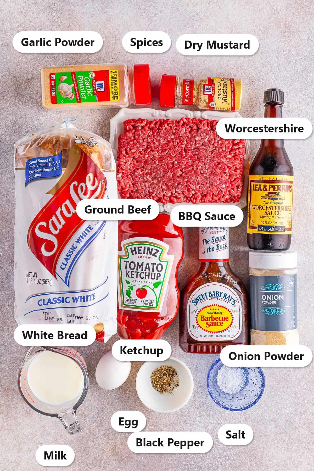 Labeled ingredients for air fryer meatloaf including ground beef, white bread, milk, egg, ketchup, BBQ sauce, Worcestershire, and seasonings.