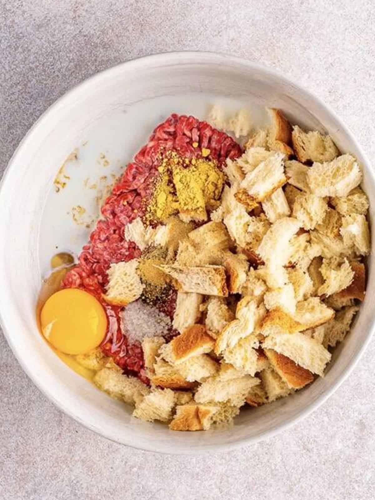 Meatloaf ingredients combined in a large mixing bowl for air fryer meatloaf.