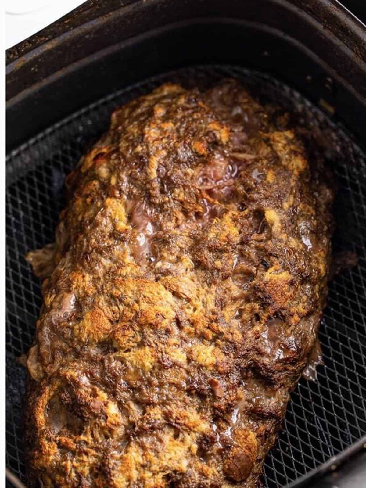 Air fryer meatloaf after the first fifteen minutes of cooking.