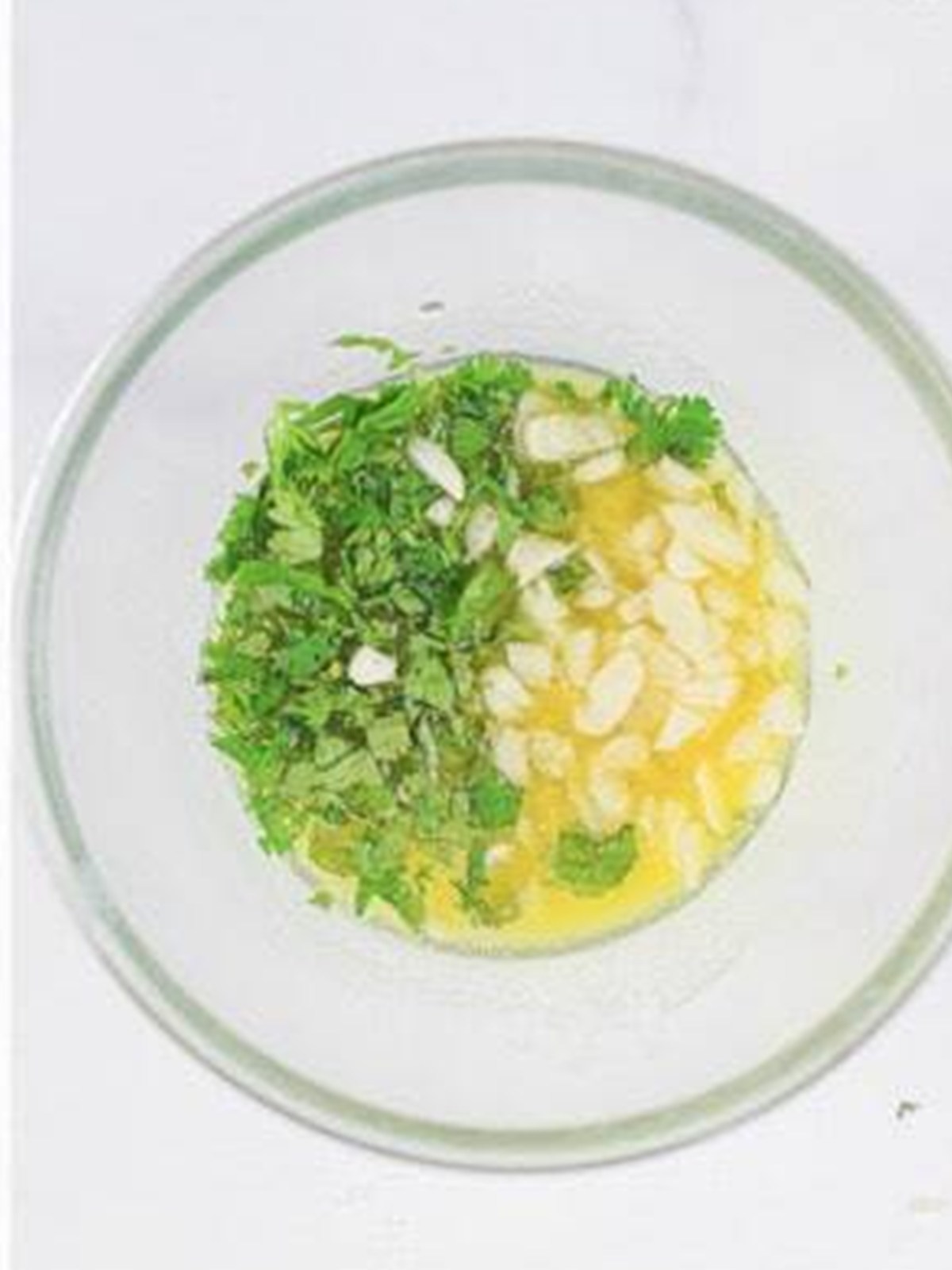 Garlic butter with melted butter, cilantro, and garlic in a bowl.