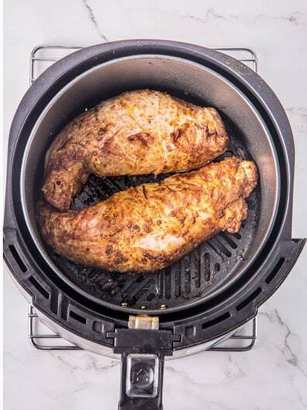 Golden cooked Air Fryer Pork Tenderloin in the basket.