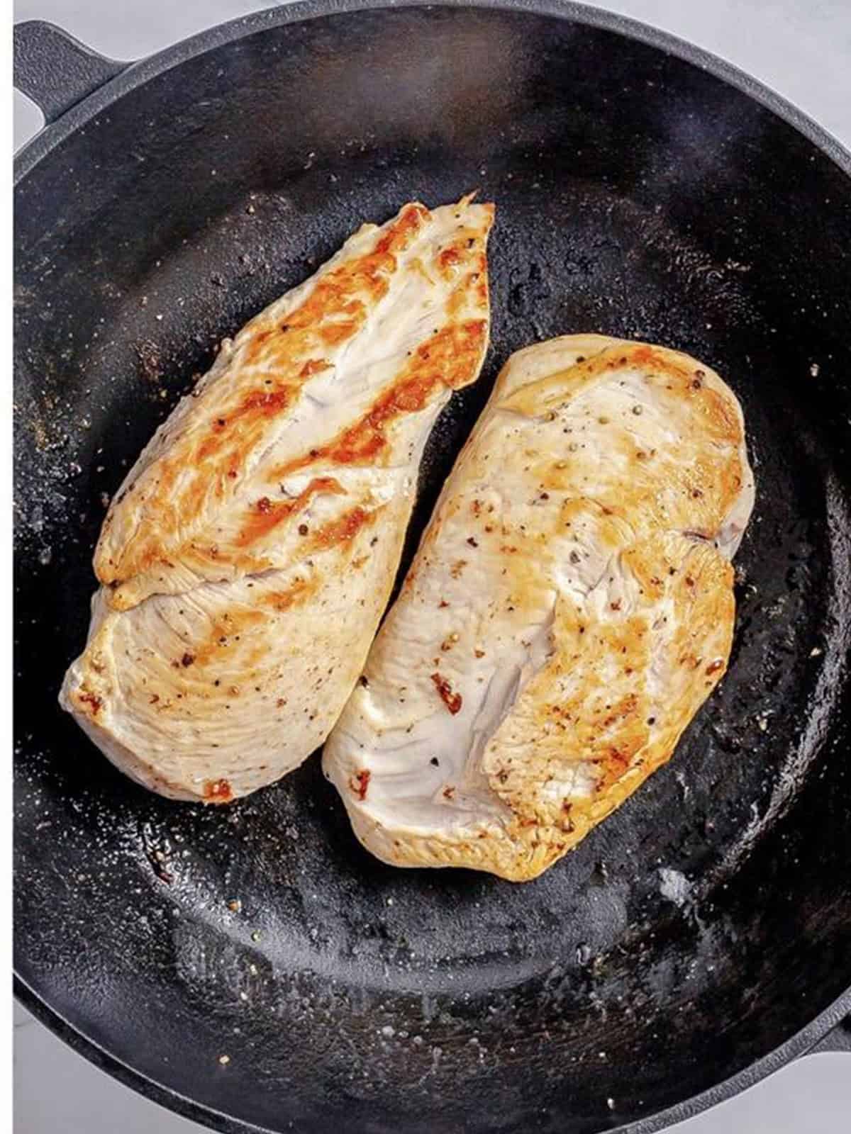 Seasoned chicken breasts seared golden in the bacon fat.