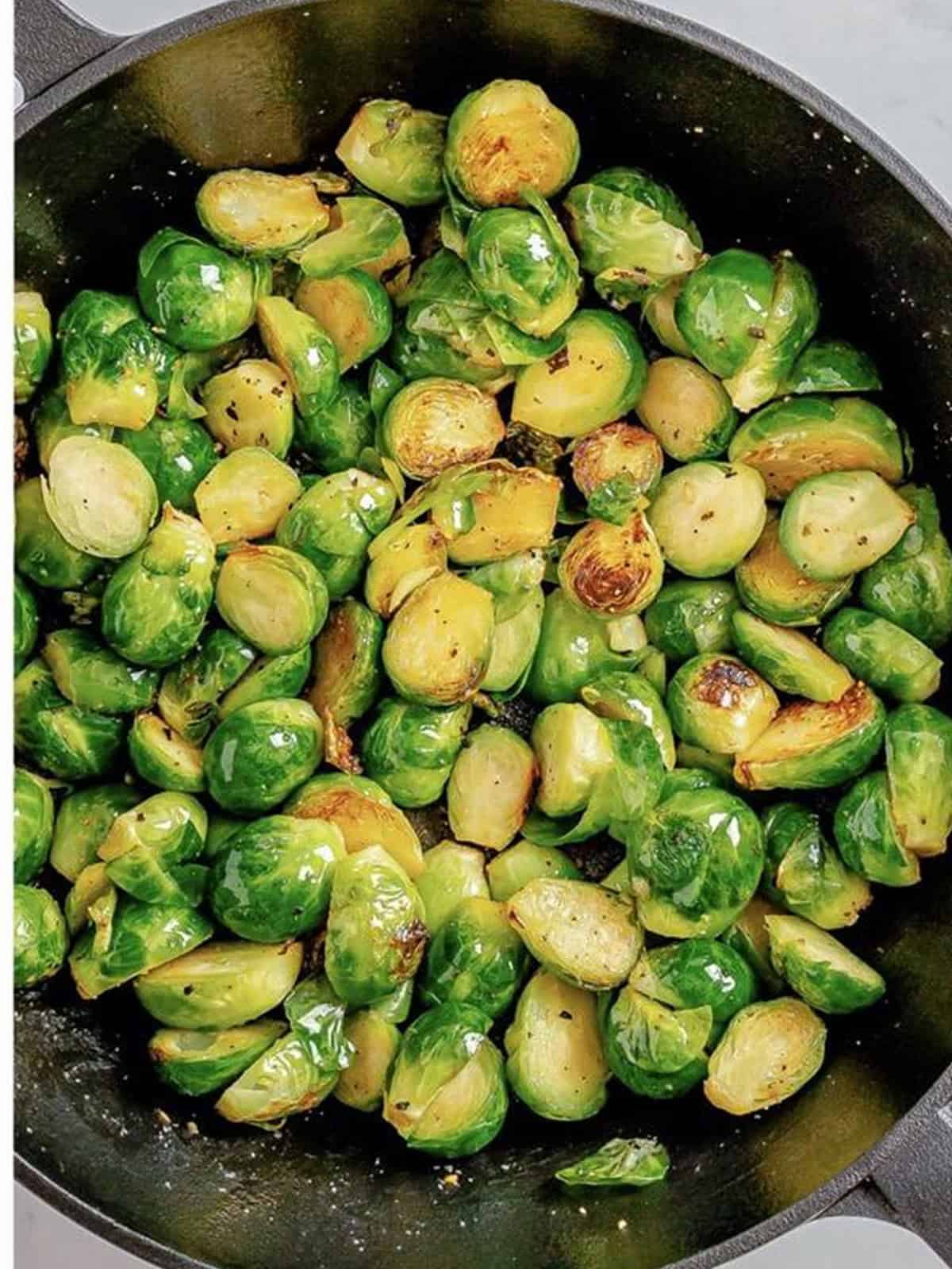 Halved Brussels sprouts seared in butter in the skillet.