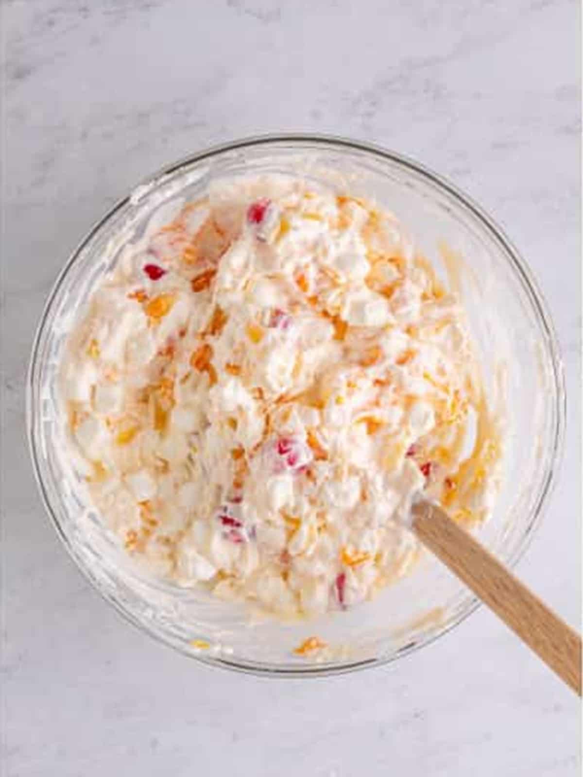 Finished ambrosia salad in a bowl with fruit, coconut, and marshmallows.