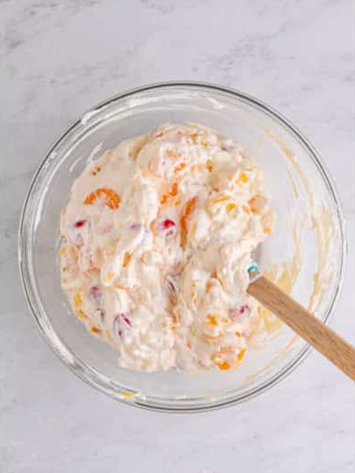 Fruit folded into the creamy base for ambrosia salad.
