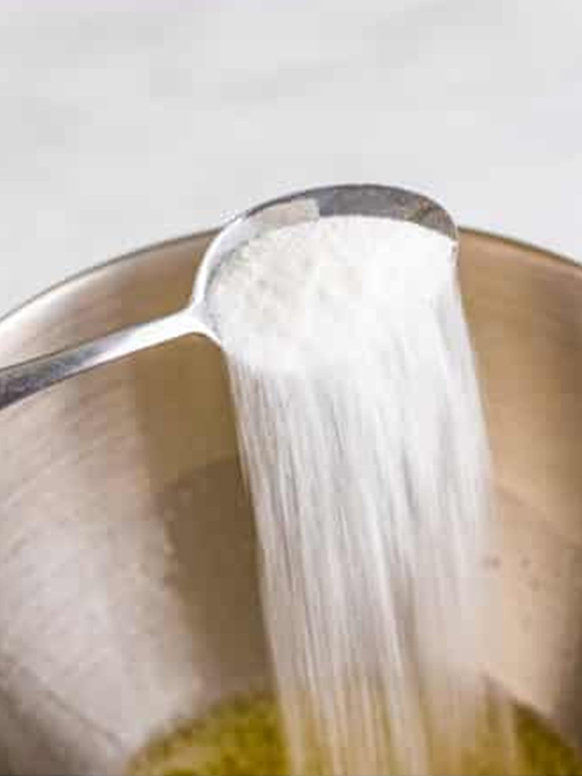 Sugar streamed into whipping egg whites in a stand mixer for angel food cake.