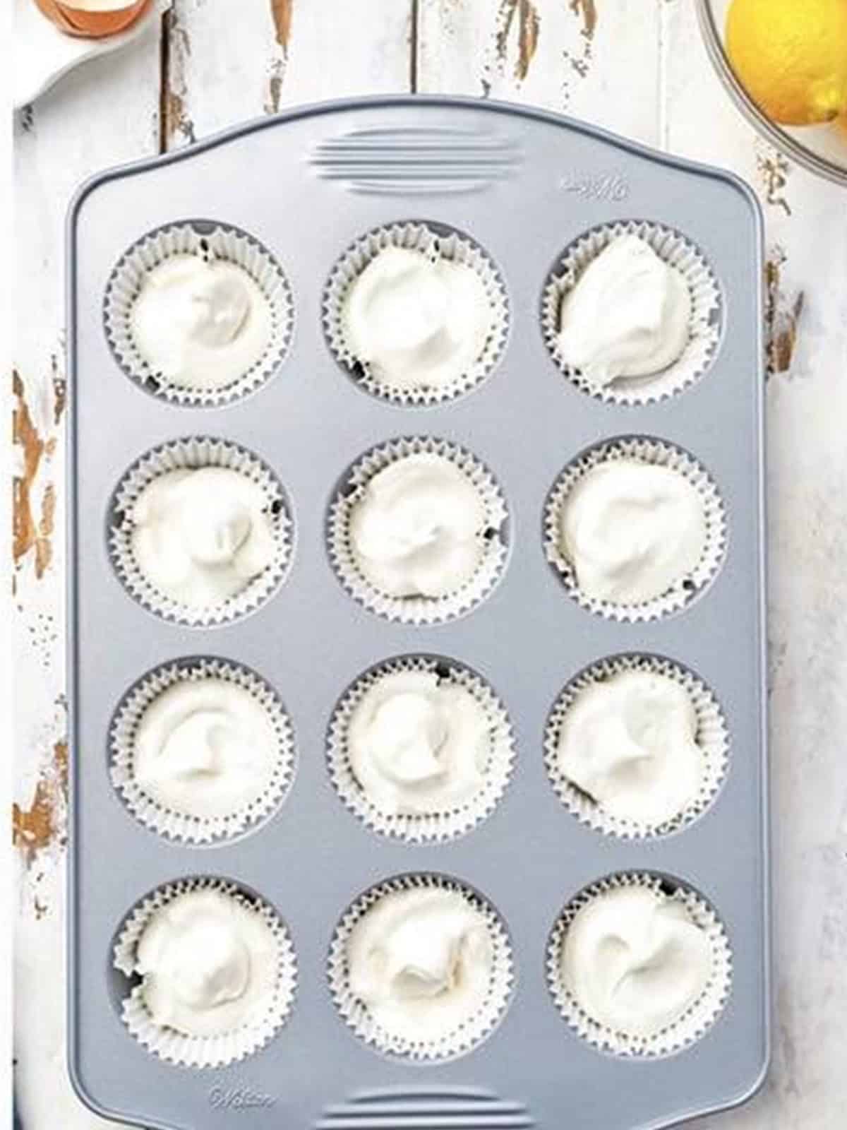 Angel food cupcake batter piped into a lined cupcake tin.