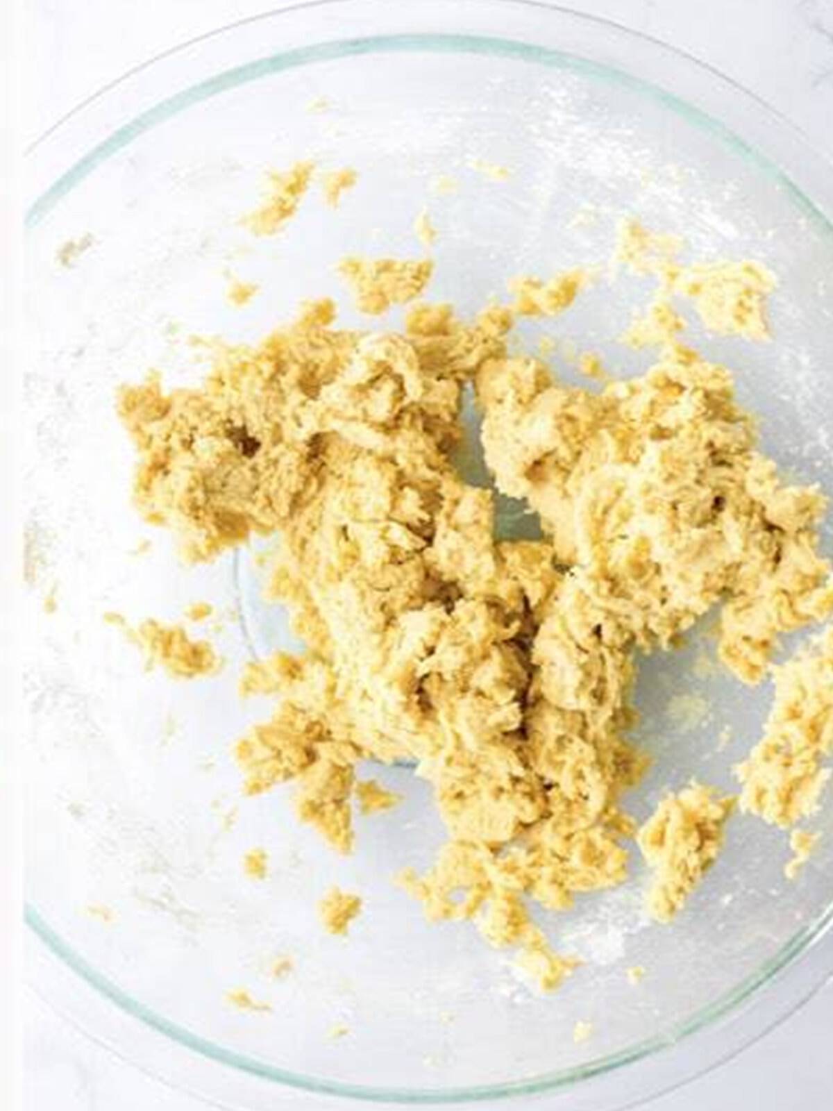 Animal cracker cookie dough mixed together in a glass bowl.