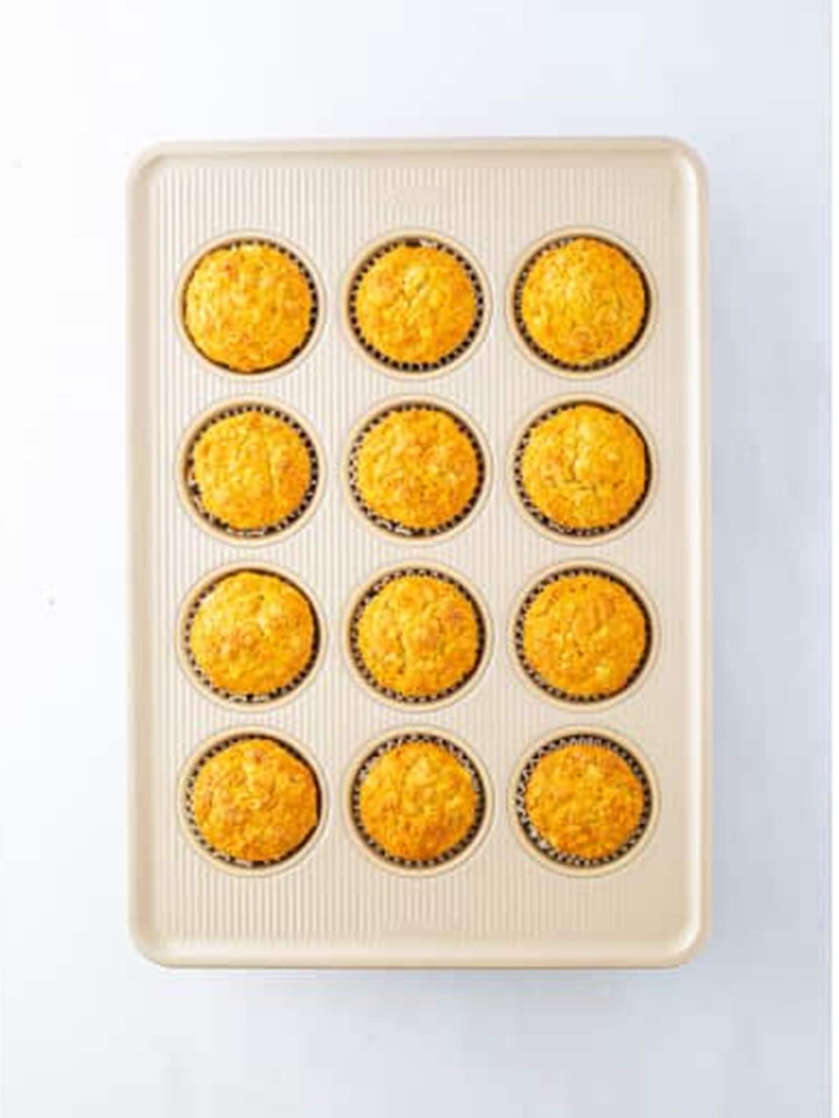 Golden baked apple banana muffins fresh from the oven in the muffin tin.
