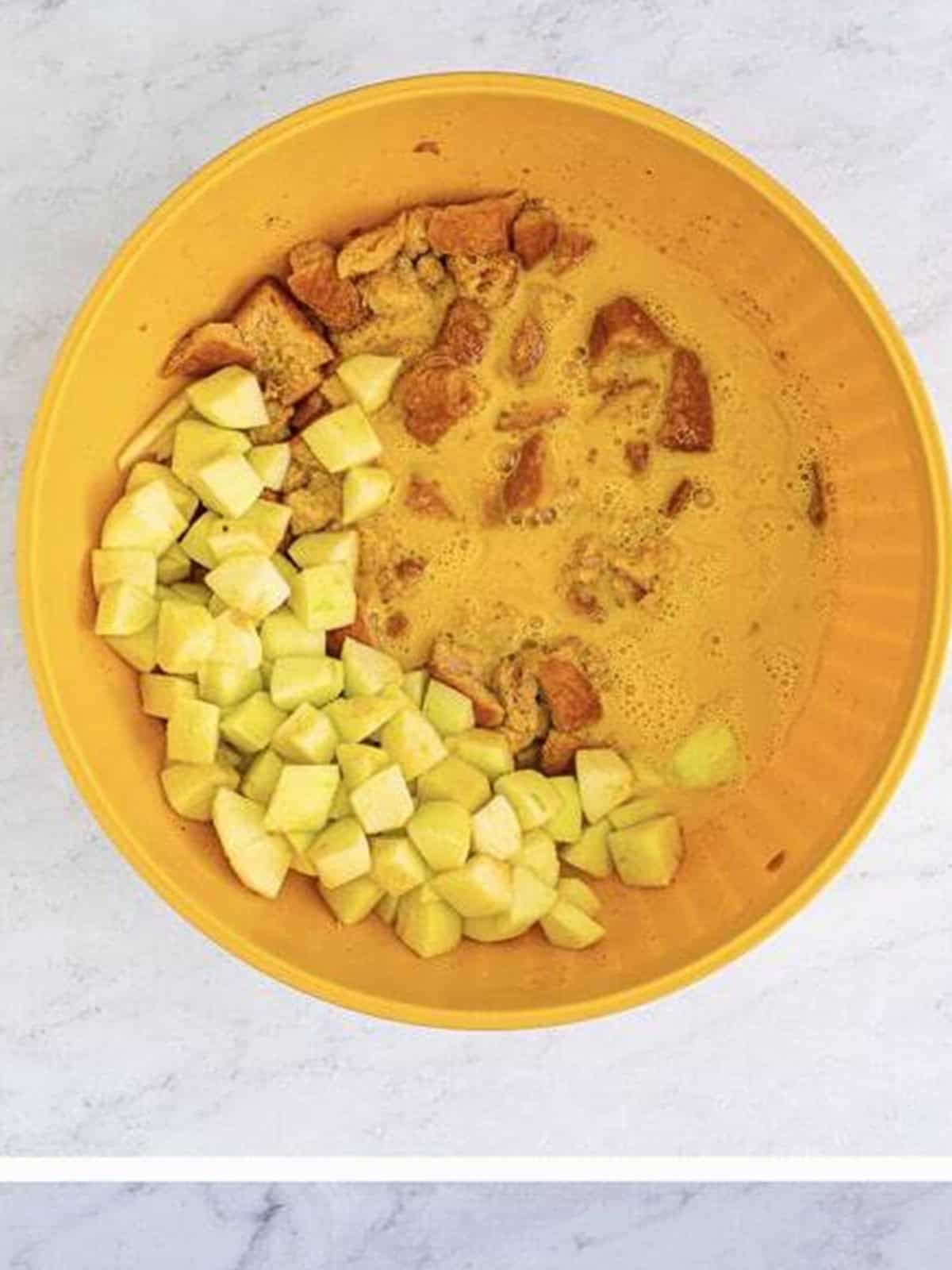 Brioche bread cubes and diced Granny Smith apples in a bowl ready to soak.