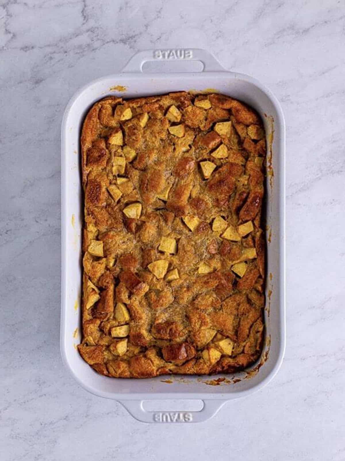 Golden baked Fireball apple bread pudding in a baking dish.